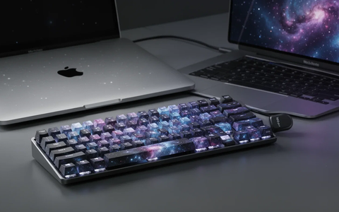 A Lofree Flow 2 mechanical keyboard in a dark blue color next to a silver MacBook Neo laptop on a minimalist desk. - Foto: über boerse-global.de