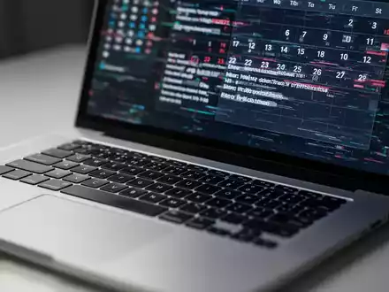 A close-up of a laptop keyboard with a blurred, glitchy calendar application on the screen, indicating a software error. - Foto: über boerse-global.de