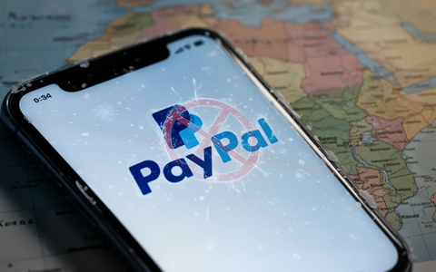 A smartphone displaying the PayPal logo, with a map of Kenya in the background, symbolizing financial restrictions. - Foto: über boerse-global.de