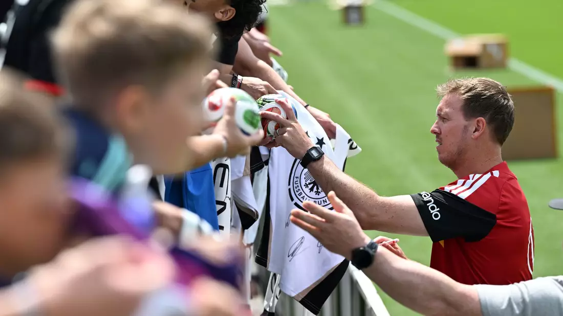 Julian Nagelsmann schreibt Autogramme für Fans der Nationalmannschaft (Archivbild).  - Bild: Federico Gambarini/dpa