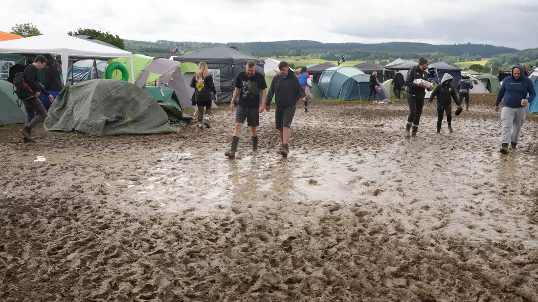 Viele Camper setzen bei Rock am Ring auf Gummistiefel, um trockene Füße zu behalten.  - Bild: Thomas Frey/dpa