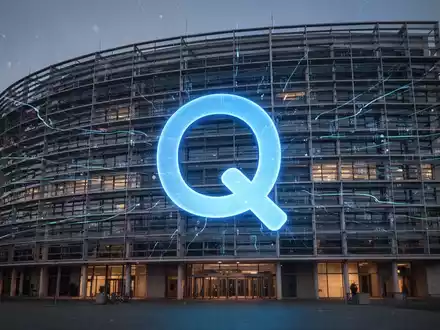 Das Europäische Parlament bei Nacht, mit einem stilisierten, leuchtenden blauen 'Q'-Logo, das in die Architektur integriert ist. - Foto: über boerse-global.de