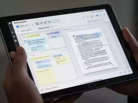 A close-up of a hand holding a Samsung Galaxy tablet displaying the Samsung Notes app with digital notes and a PDF. - Foto: über boerse-global.de