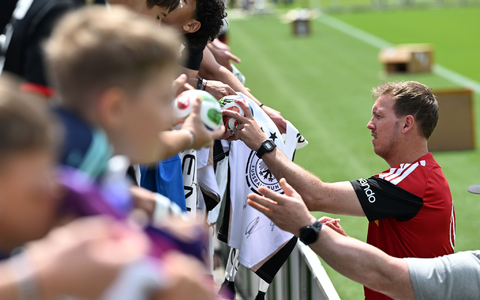 Julian Nagelsmann schreibt Autogramme für Fans der Nationalmannschaft (Archivbild).  - Bild: Federico Gambarini/dpa