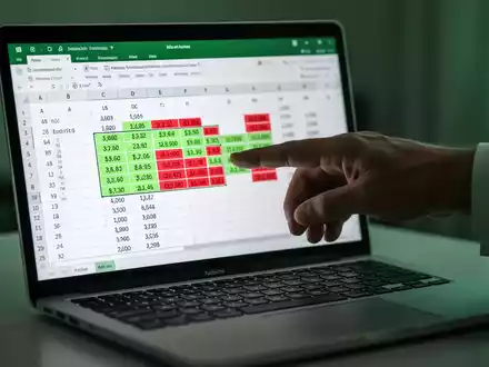 A hand pointing at a laptop screen displaying an Excel spreadsheet with highlighted duplicate cells, illustrating data analysis. - Foto: über boerse-global.de