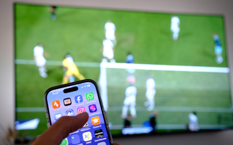 Nebenbei mal daddeln: Während das Fußballspiel läuft, schauen viele Zuschauer nebenbei aufs Handy. (Symbolbild) - Bild: Bernd Weißbrod/dpa