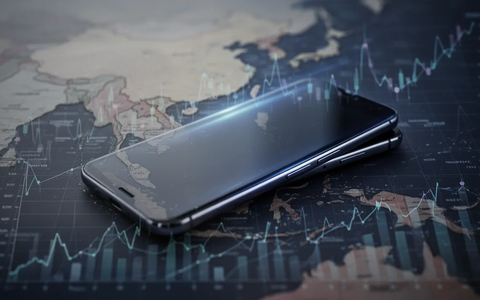 A modern smartphone with a subtle glow, overlaid on a blurred map of South Asia and Southeast Asia with financial charts. - Foto: über boerse-global.de