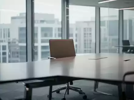 Ein leerer Stuhl an einem modernen Konferenztisch in einem hellen Bürogebäude, der eine neue Aufsichtsratsposition symbolisiert. - Foto: über boerse-global.de