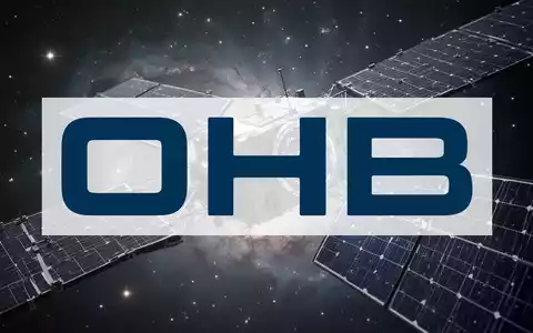 Ein detaillierter Blick auf einen modernen Satelliten mit ausgebreiteten Solarpaneelen vor einem Hintergrund aus Sternen und Nebeln. - Foto: über boerse-global.de