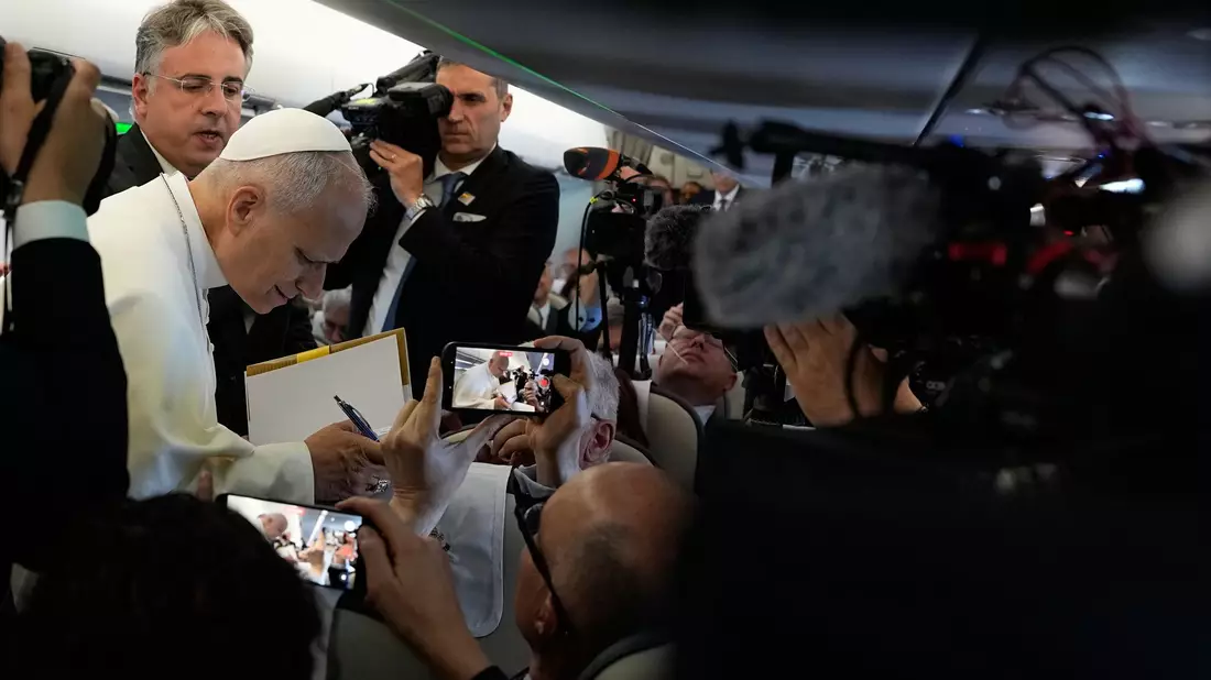 Papst Leo XIV. spricht während des Flugs nach Spanien mit mitreisenden Journalisten.  - Bild: Alessandra Tarantino/Pool AP/AP/dpa