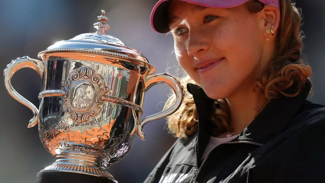 Mirra Andrejewa lächelt mit der Trophäe in den Händen. - Bild: Aurelien Morissard/AP/dpa