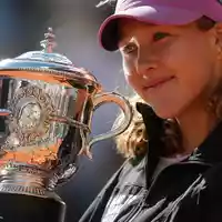 Mirra Andrejewa lächelt mit der Trophäe in den Händen. - Foto: Aurelien Morissard/AP/dpa