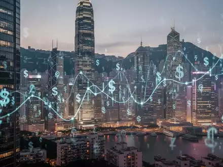Finanzviertel in Hongkong bei Sonnenuntergang mit leuchtenden Gebäuden und subtilen digitalen Währungssymbolen, die Investitionen darstellen. - Foto: über boerse-global.de