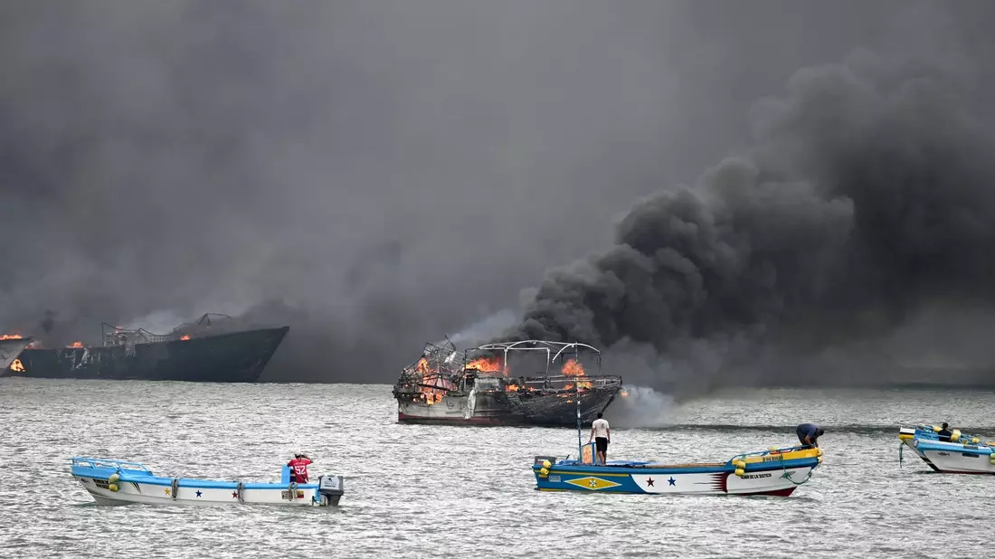 Im Hafen von Manta stehen mehrere Fischerboote in Flammen. - Bild: Ariel Ochoa/AP/dpa