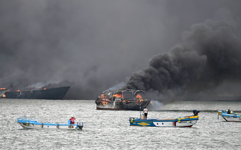 Im Hafen von Manta stehen mehrere Fischerboote in Flammen. - Bild: Ariel Ochoa/AP/dpa