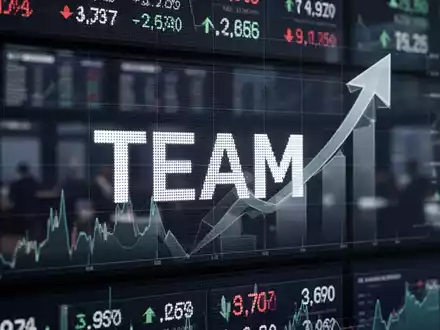Nahaufnahme eines Börsentickers mit dem Symbol 'TEAM' und einem stilisierten Pfeil nach oben, auf einem modernen Handelsparkett. - Foto: über boerse-global.de