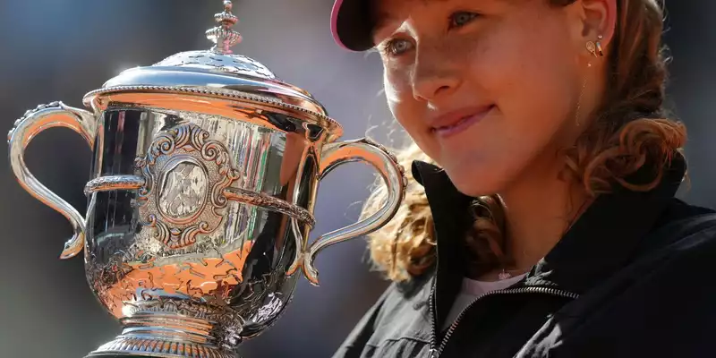 Mirra Andrejewa lächelt mit der Trophäe in den Händen. - Foto: Aurelien Morissard/AP/dpa