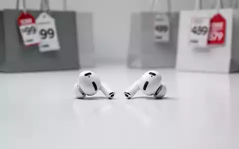 A pair of white Apple AirPods 4 earbuds on a clean surface, with a blurred background suggesting retail sales. - Foto: über boerse-global.de