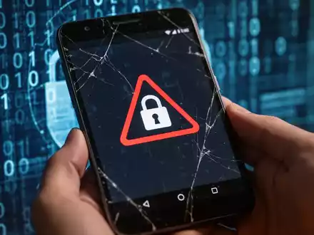 Ein gebrauchtes Android-Smartphone mit einem Warnsymbol auf dem Bildschirm, das Sicherheitsbedenken beim Kauf alter Handys symbolisiert. - Foto: über boerse-global.de