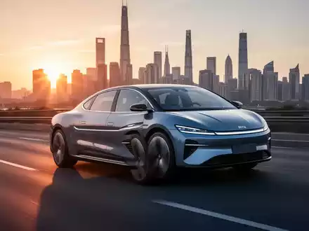 Ein elegantes Elektrofahrzeug fährt bei Sonnenuntergang auf einer Autobahn vor einer verschwommenen globalen Stadtkulisse. - Foto: über boerse-global.de