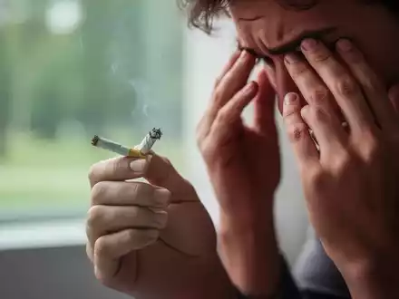 Eine Hand hält eine zerknüllte, erloschene Zigarette, während die andere Hand die Stirn berührt, symbolisiert Stress und den Rauchstopp. - Foto: über boerse-global.de