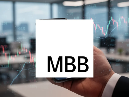 Eine Hand hält ein Smartphone mit einer Börsen-App, die einen steigenden Aktienkurs zeigt, vor einem unscharfen Bürohintergrund. - Foto: über boerse-global.de
