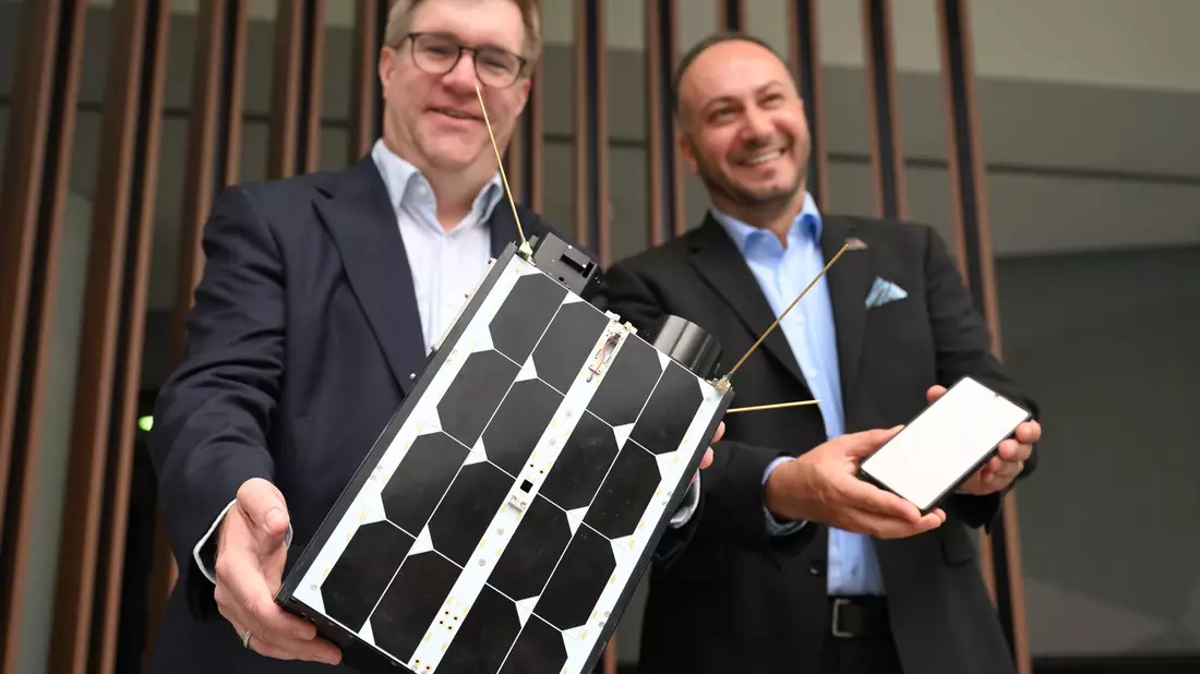 Demonstrativ gute Laune von O2-Manager Jörg Kablitz und OQ-Chef Omar Qaise, die bei der Vorstellung ihres Vorhabens ein Modell eines Satelliten dabeihatten.  - Bild: Wolf von Dewitz/dpa