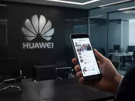 A hand subtly holding a smartphone with a social media interface, the Huawei logo in the background. - Foto: über boerse-global.de