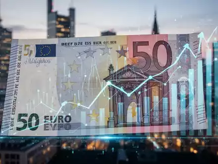 A close-up of a 50 euro banknote with digital financial graphs overlaid, set against a blurred city skyline. - Foto: über boerse-global.de