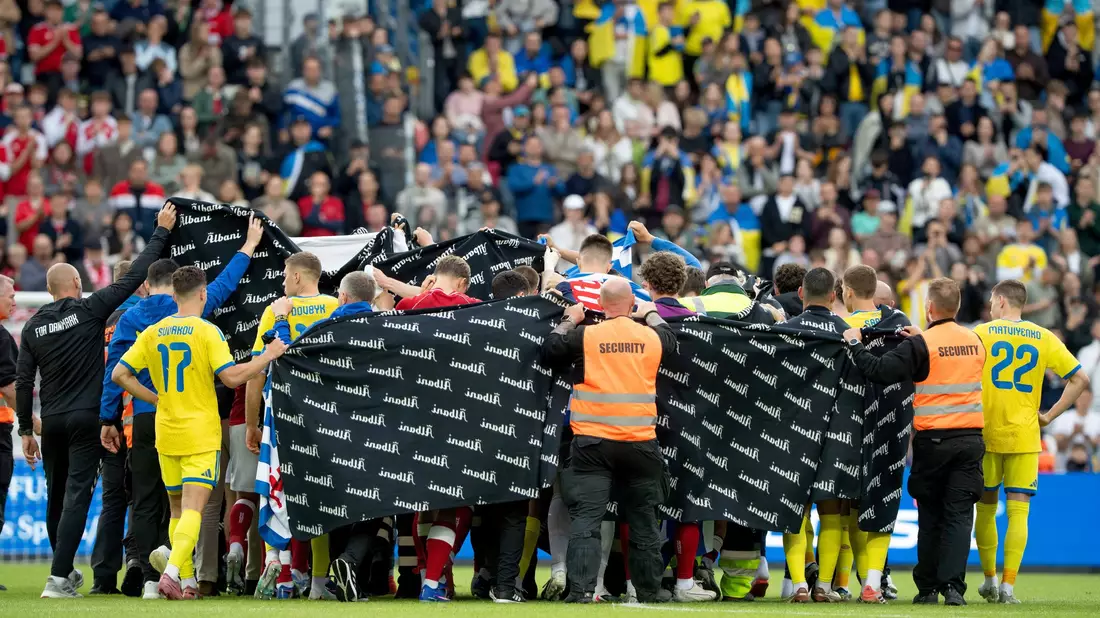 Die Spieler aus Dänemark und der Ukraine schirmen Christian Eriksen nach seinem Zusammenbruch ab.  - Bild: Bo Amstrup/Ritzau Scanpix Foto/AP/dpa