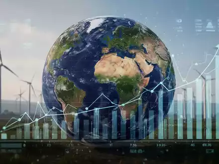 Eine Weltkugel, die teilweise von stilisierten Diagrammen und Finanzdaten überlagert wird, im Hintergrund angedeutete erneuerbare Energien. - Foto: über boerse-global.de