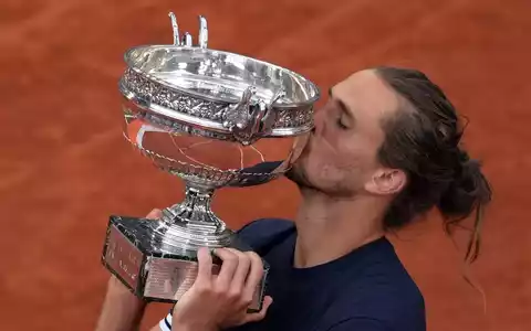 Alexander Zverev gibt der Trophäe einen Kuss.  - Bild: Thibault Camus/AP/dpa