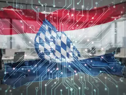 Eine stilisierte, leuchtende Platine mit einer Umrandung der bayerischen Flagge, die digitale Souveränität und Technologie symbolisiert. - Foto: über boerse-global.de
