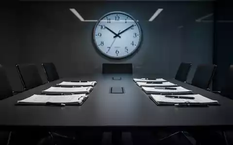Ein Konferenztisch mit Dokumenten, der zwei streitende Parteien symbolisiert, und eine Uhr, die eine späte Stunde anzeigt. - Foto: über boerse-global.de