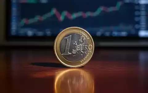 Eine einzelne Euro-Münze liegt auf einer dunklen Holzoberfläche, im Hintergrund unscharf eine Finanzgrafik. - Foto: über boerse-global.de