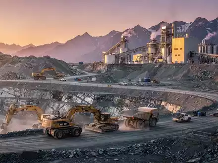 Eine moderne Silbermine in einer bergigen Landschaft bei Sonnenaufgang mit schweren Maschinen und einer Verarbeitungsanlage. - Foto: über boerse-global.de