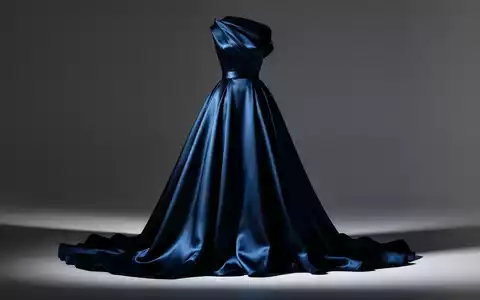 Ein elegantes, fließendes Haute-Couture-Kleid aus luxuriösem Stoff mit weicher, dramatischer Beleuchtung. - Foto: über boerse-global.de