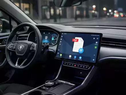 A close-up of a car's digital dashboard showing the Android Auto interface with an Adobe Acrobat PDF icon displayed, symbolizing in-car document access. - Foto: über boerse-global.de