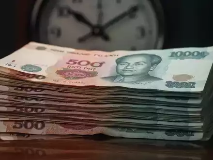 Nahaufnahme von vietnamesischen ??ng-Banknoten mit einer verschwommenen Uhr im Hintergrund. - Foto: über boerse-global.de