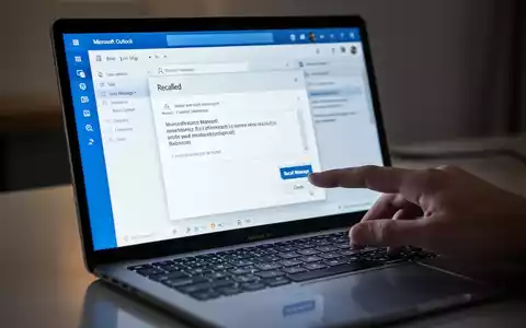 A close-up of a laptop screen showing the Microsoft Outlook interface with an email recall message and a hand hovering over the 'Recall Message' button. - Foto: über boerse-global.de