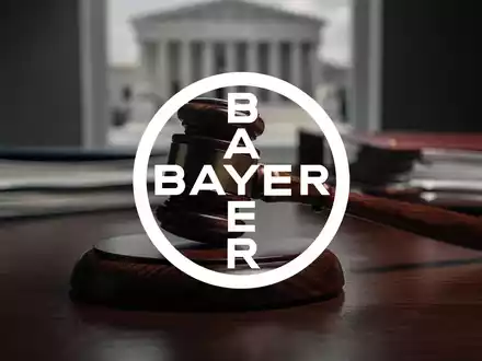 Ein Nahaufnahme eines Richterhammers auf einem dunklen Holzschreibtisch mit unscharfen juristischen Dokumenten im Hintergrund. - Foto: über boerse-global.de
