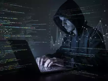 Eine Person im Kapuzenpulli tippt auf einem Laptop, umgeben von Code und einem Netzwerkdiagramm, das Cyberangriff und VPN-Umgehung darstellt. - Foto: über boerse-global.de