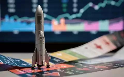 Eine Miniaturrakete von SpaceX steht auf einem Börsentickerband, im Hintergrund verschwommene Finanzdaten und Charts. - Foto: über boerse-global.de