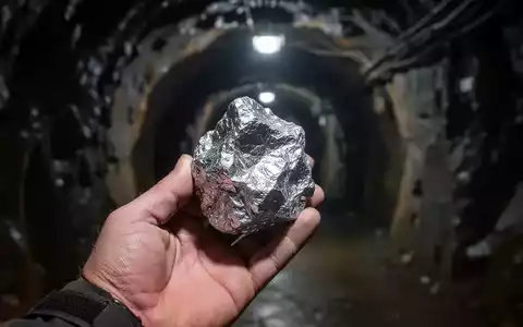 Nahaufnahme einer Hand, die ein hochgradiges Silbererzmuster in einem Bergwerkstunnel hält. - Foto: über boerse-global.de