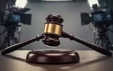 Ein Gavel schlägt auf einen Klangblock, im Hintergrund verschwommen Medienausrüstung. Symbolisiert regulatorisches Eingreifen. - Foto: über boerse-global.de