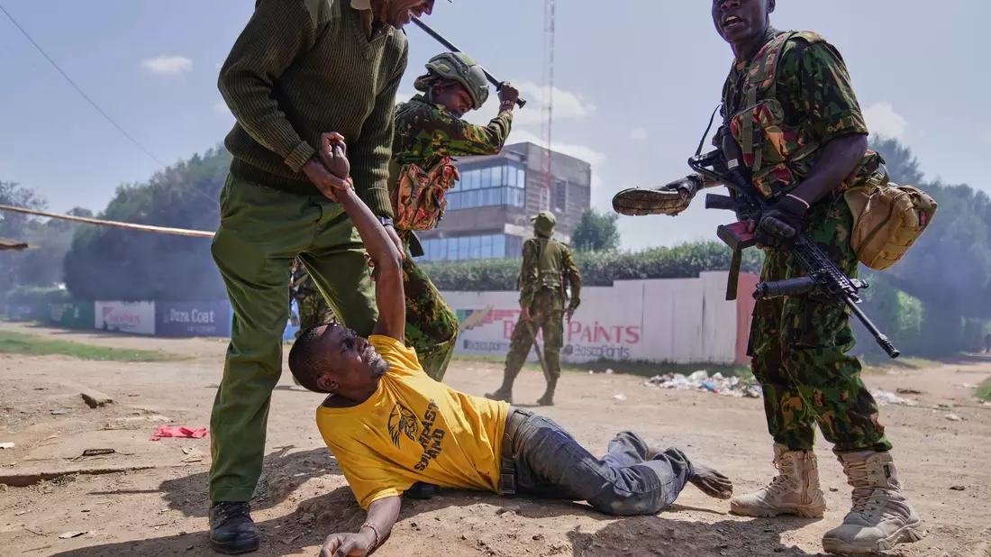 Ein Demonstrant wird in Kenia bei Protesten gegen ein von den USA geplantes Ebola-Quarantänezentrum auf dem Luftwaffenstützpunkt Laikipia festgenommen. - Bild: Brian Inganga/AP/dpa