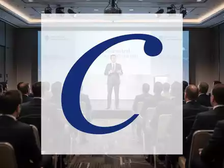 Ein Redner präsentiert auf einer Bühne vor einem Publikum in einem modernen Konferenzraum mit Finanzthemen. - Foto: über boerse-global.de