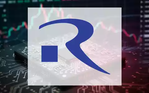 Nahaufnahme eines komplexen Mikrochips mit unscharfem, fallendem Börsenchart im Hintergrund, der einen Rückgang symbolisiert. - Foto: über boerse-global.de