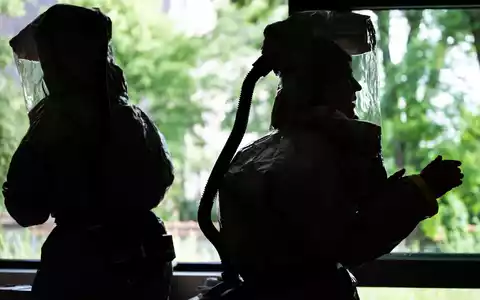 Auf der Isolierstation müssen Mitarbeiter Schutzanzüge tragen. - Foto: Soeren Stache/dpa