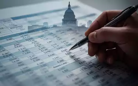 Eine Hand, die mit einem Stift auf eine Finanzübersicht zeigt, mit einer verschwommenen Silhouette eines Regierungsgebäudes im Hintergrund. - Foto: über boerse-global.de